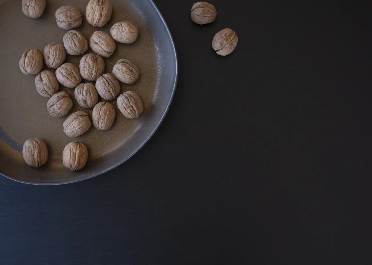 Walnuts in a ceramic dish on a dark table